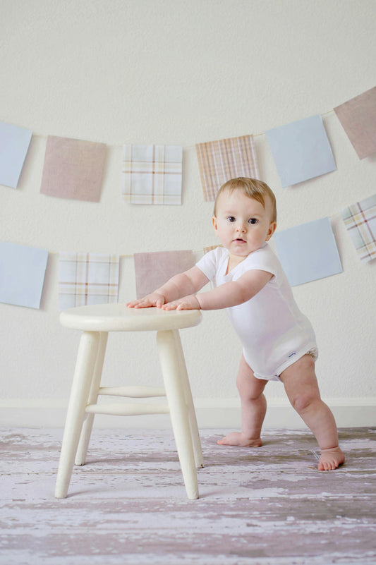 Baby steht am Tisch